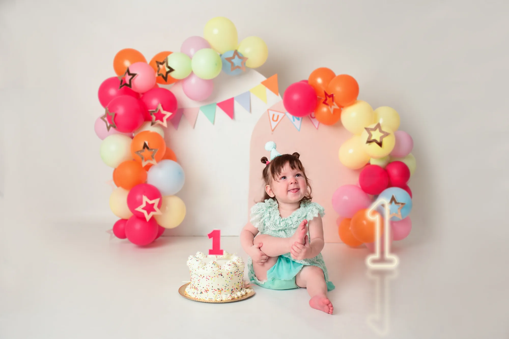 Fotografía infantil de Cake Smash de primer añito en Lomas del Mirador: bebé con torta y globos rosados